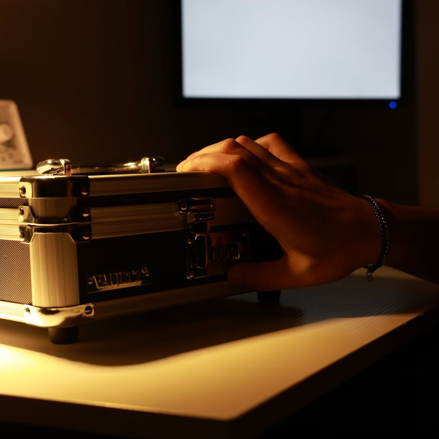 A hand opening a briefcase inside the Denver Bank Heist escape room