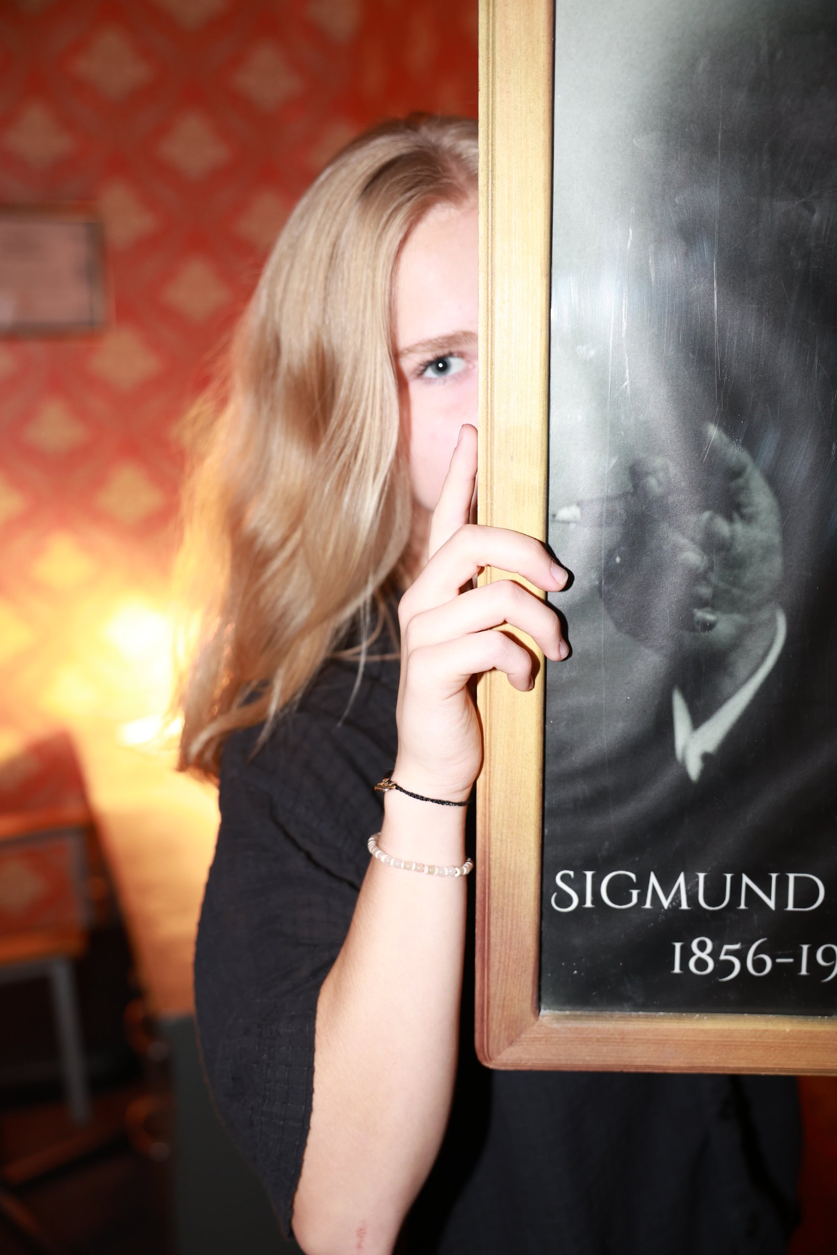 A woman beside the Sigmund Freud portrait inside the asylum