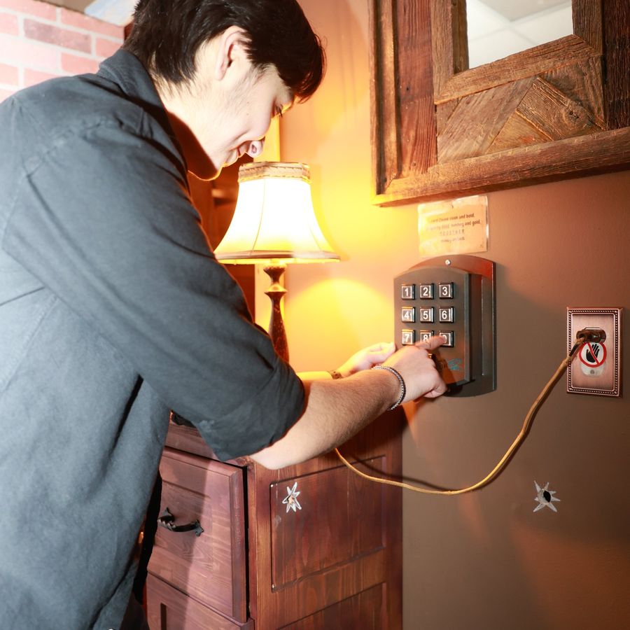 A man entering a keypad code in the Blood Money escape room