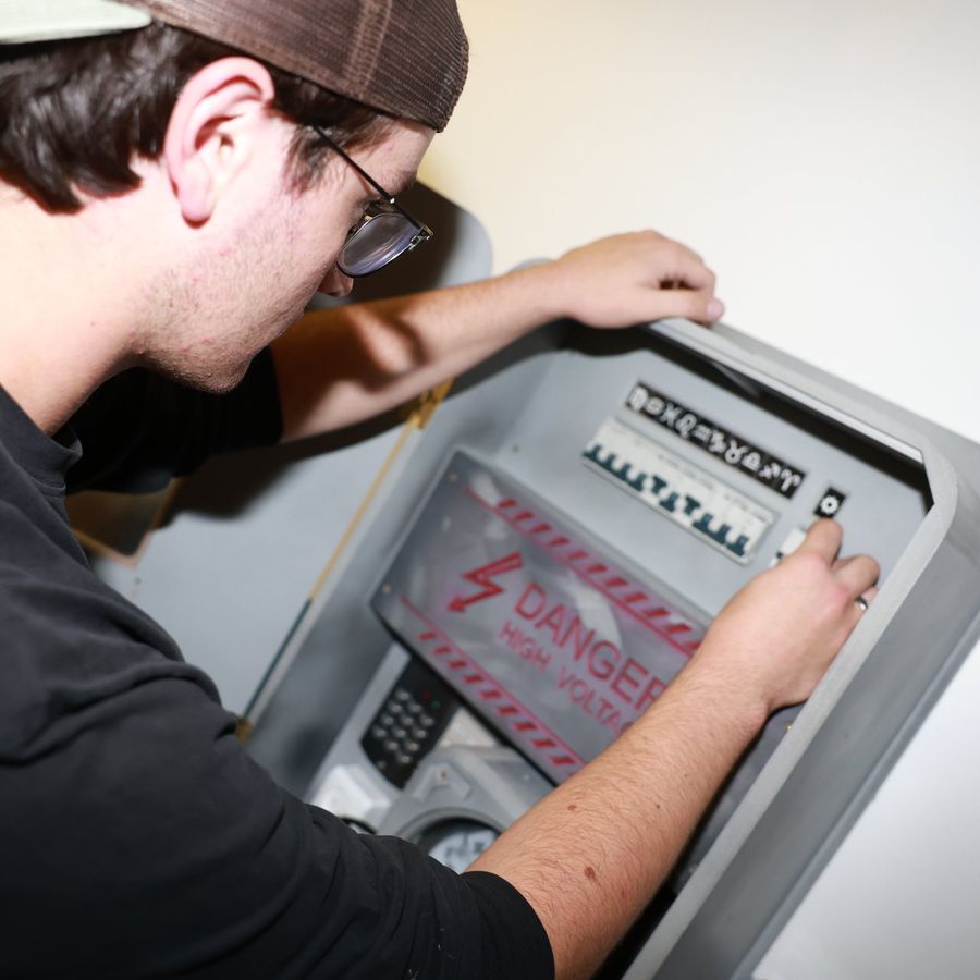 A player solving the high voltage panel puzzle in the Madhouse escape room
