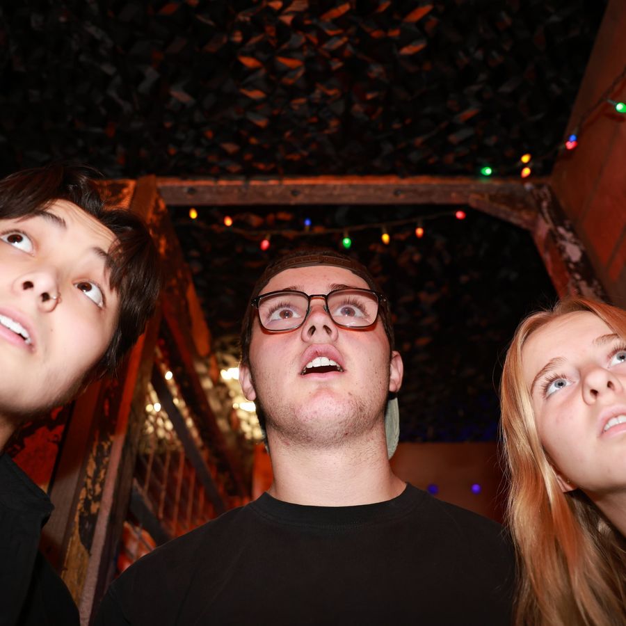A team looking up scared at the Alien Escape ceiling reveal