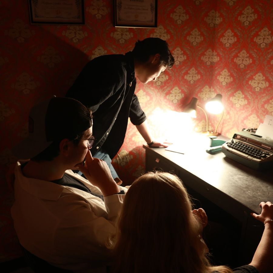 A team studying a typewriter clue inside the Madhouse asylum